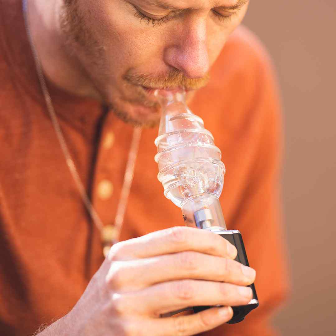 Linx Apollo: smallest Dab Rig and E Nail in Portable Dab Rig mode in use by a man in an orange shirt 
